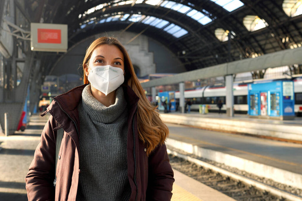 Retrato de mujer de negocios esperando tren con máscara de protección médica en la estación de tren en invierno - Foto, Imagen