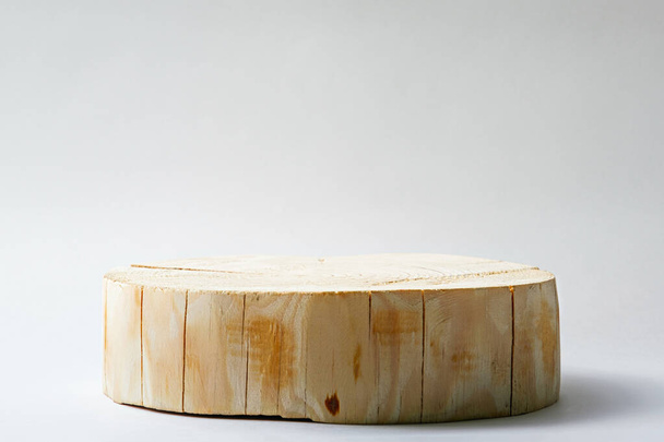 yksi pyöreä leikattu puinen alusta valkoisella pohjalla, aito geometrinen koroke, mallina, ekologinen kohtaus kauneudenhoitotuotteiden esittelyyn - Valokuva, kuva