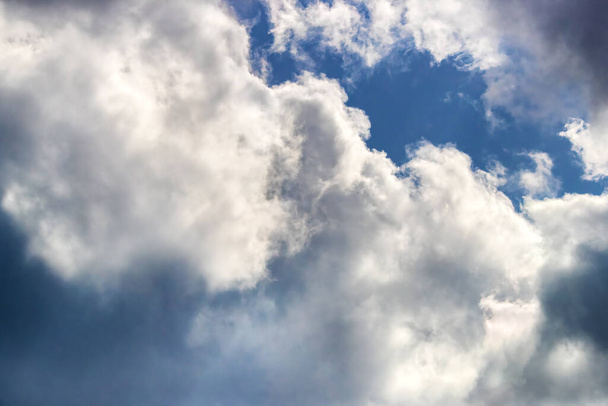 La lumière du soleil brille dans un paysage nuageux orageux. Ciel bleu et cumulonimbus fond nuageux orageux avec espace pour le texte ou l'utilisation comme toile de fond, superposition ou élément de composition.  - Photo, image