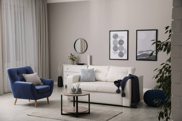 Stylish living room interior with white sofa, armchair and small coffee table - Foto, Bild