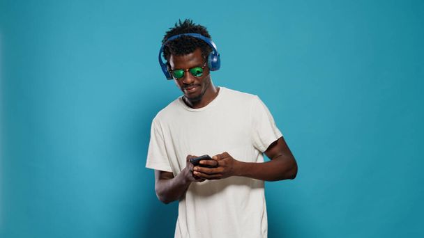 Zıplayan ve akıllı telefon kullanırken müzik dinleyen kişi - Fotoğraf, Görsel