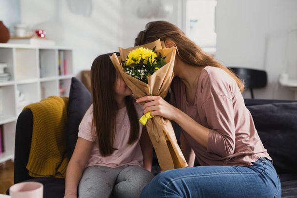 daughter giving flowers to her mother - Foto, Imagen