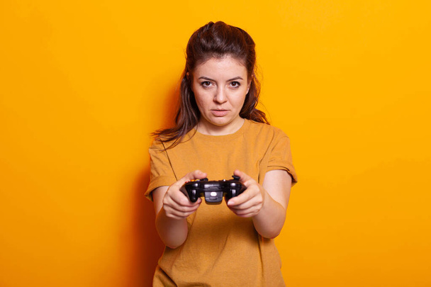 Portrait of woman holding controller in front of camera - Valokuva, kuva