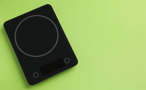 Modern digital kitchen scale on light green background, top view. Space for text - Zdjęcie, obraz