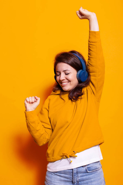 Χαρούμενος ενήλικας απολαμβάνοντας το τραγούδι στα ακουστικά και το χορό - Φωτογραφία, εικόνα
