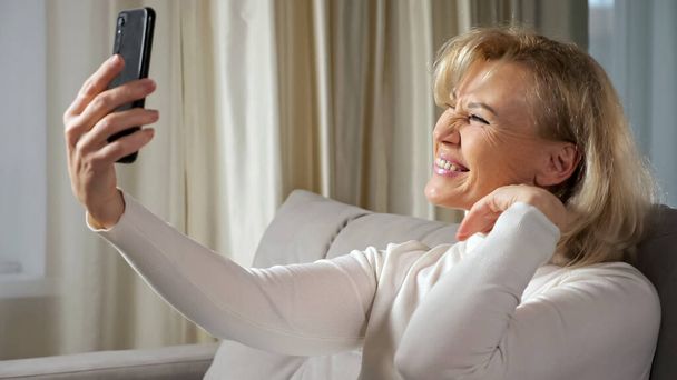 Anciana rubia toma selfies usando el teléfono celular - Foto, Imagen