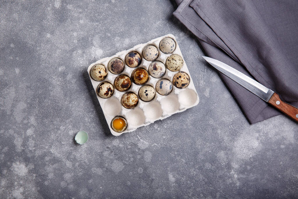 Quail eggs in cardboard packaging on gray background . Top view, copy space. - Photo, Image