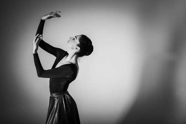 Eine junge elegante, emotionale Balletttänzerin in professioneller Kleidung demonstriert ihre tänzerischen Fähigkeiten, ihre Handbewegungen. Die Schönheit des klassischen Balletts. Zurückhaltend, Tschernobyl-Foto - Foto, Bild