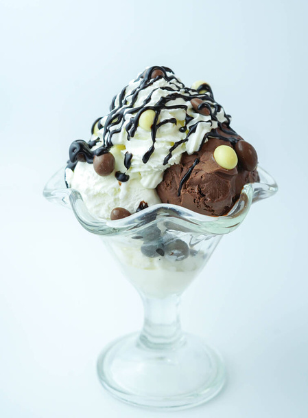Scoops of ice cream with chocolate balls and syrup - Foto, afbeelding