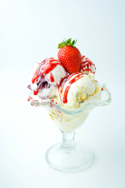 Cup with three balls of banana, cream and strawberry ice cream - Foto, afbeelding