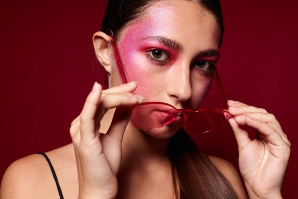 Muotokuva kaunis nuori nainen vaaleanpunainen lasit meikki tunteita kosmetiikka lähikuva muuttamaton - Valokuva, kuva