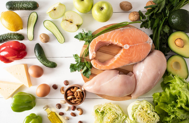 healthy food with a high content of vitamin E and dietary fiber. food background. fresh salmon steak, chicken fillet, nuts, eggs. top view - Photo, Image