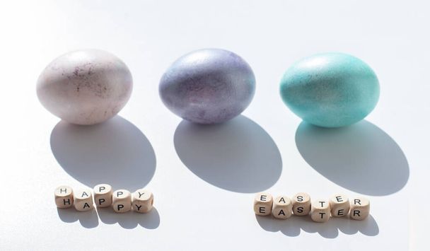 Concepto de Pascua. Huevos rosados, morados y azules sobre un fondo blanco. Minimalismo. - Foto, imagen