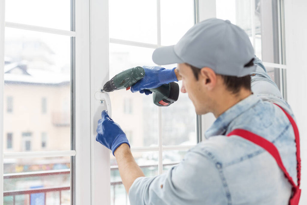 Le travailleur installant et vérifiant la fenêtre dans la maison - Photo, image