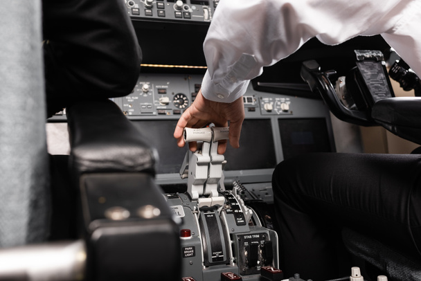 vista recortada del copiloto utilizando palanca de empuje en simulador de avión - Foto, Imagen
