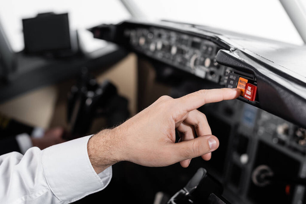 cropped view of pilot pressing master caution button in airplane simulator  - Valokuva, kuva