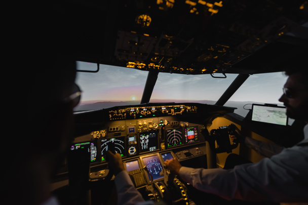 niewyraźne profesjonalistów pilotujących samolot w godzinach wieczornych podczas zachodu słońca  - Zdjęcie, obraz