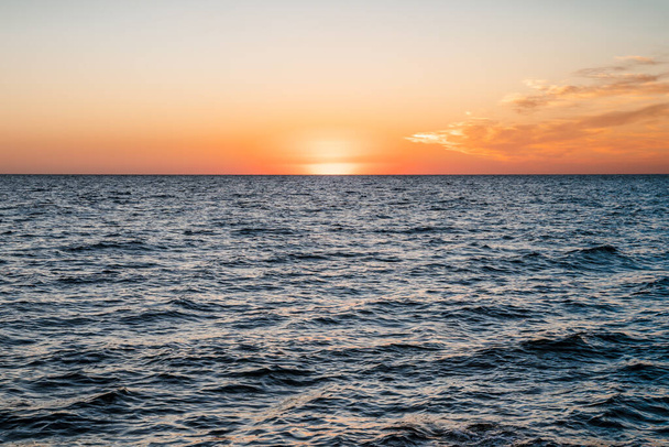 Amazing landscape on the sea with orange sunset sun, horizon line between sky and water - Photo, image