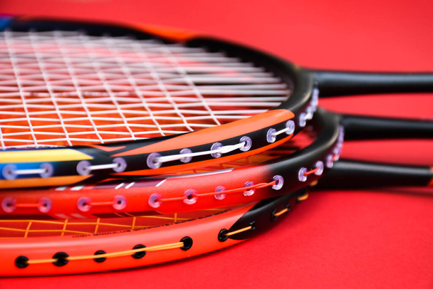 Badminton rackets on red floor in indoor badminton court, copy space, soft and selective focus. - Φωτογραφία, εικόνα