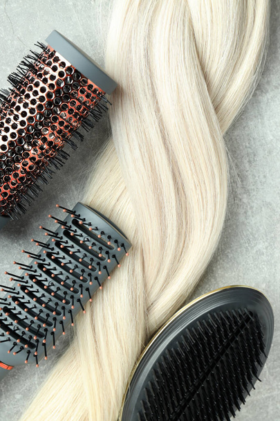 Μια τούφα ξανθά γυναικεία μαλλιά με βούρτσες μαλλιών - Φωτογραφία, εικόνα