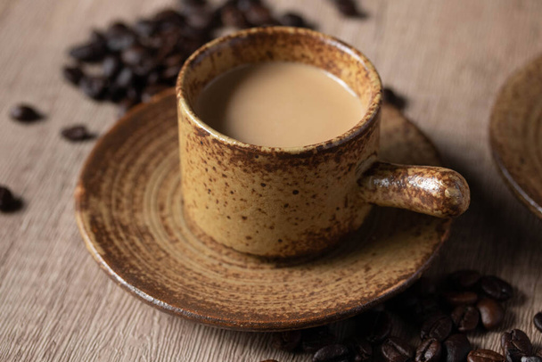 木の背景にある茶色のカップに熱いコーヒー - 写真・画像