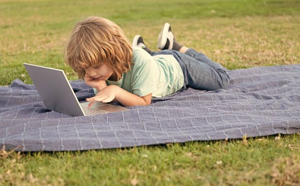 Egy kisgyerek videóórán. tini fiú laptopot használ. online oktatás. Vissza az iskolába.. - Fotó, kép
