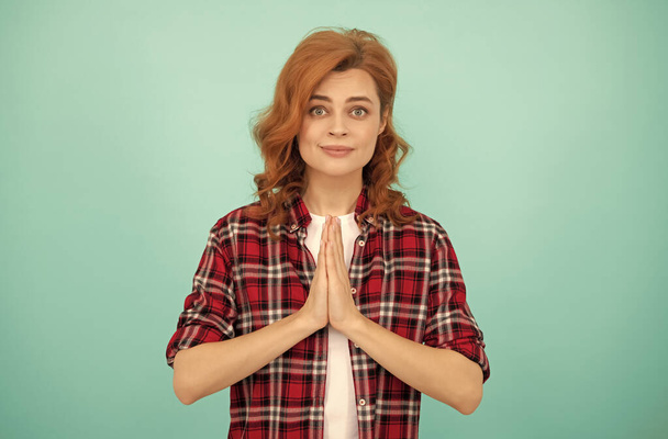 praying redhead woman with curly hair in checkered casual shirt, gesture - Photo, Image