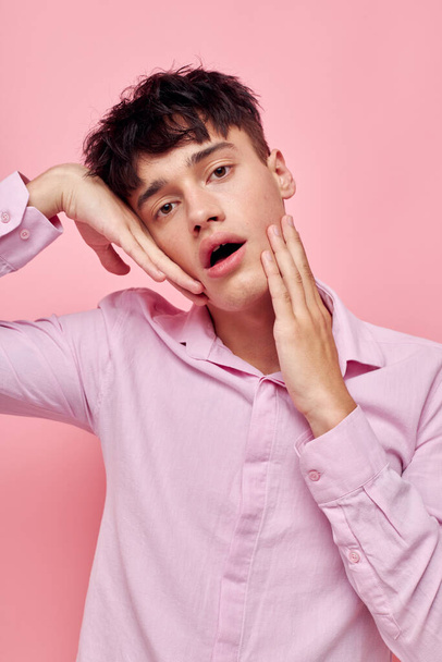 handsome guy gestures with hands emotions hairstyle fashion pink background unaltered - Zdjęcie, obraz