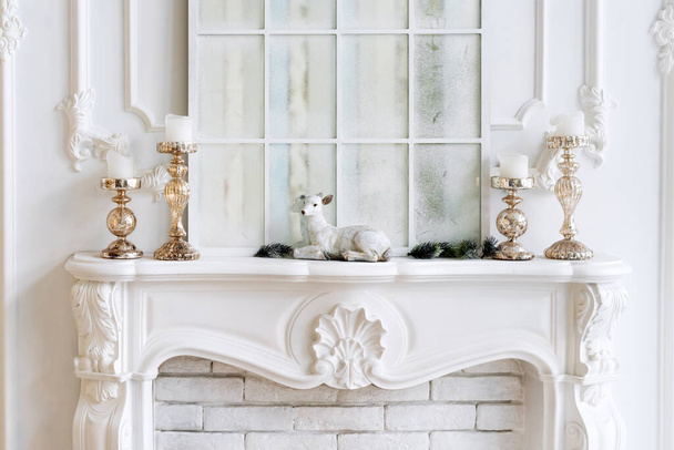 Caminetto bianco con candele e decorazioni natalizie. Interni classici. - Foto, immagini
