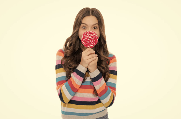 веселый ребенок в свитере с леденцами конфеты на палочке изолированы на белом фоне, стоматологическая помощь. - Фото, изображение