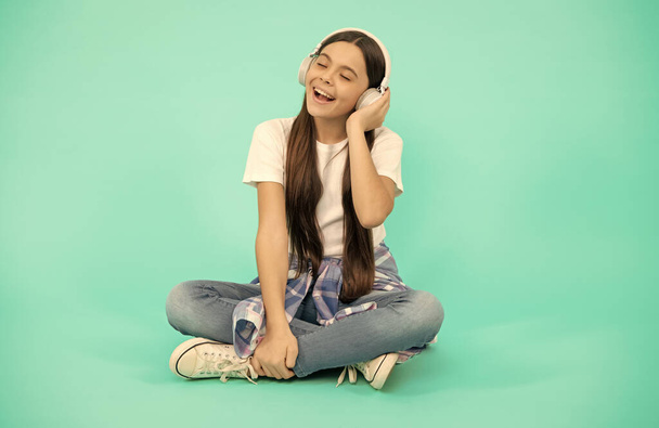 boldog gyerek lány zenét hallgatni vezeték nélküli fejhallgató, modern fülhallgató - Fotó, kép