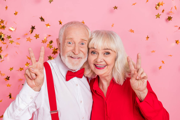 Photo of trendy pensioner retired elegant lady man make v-sign air fly confetti isolated pastel color background - Foto, afbeelding