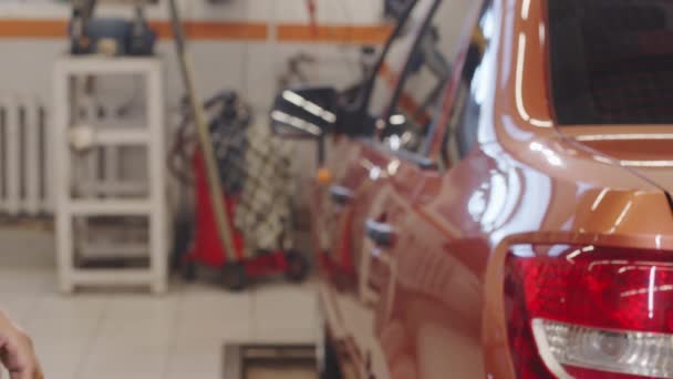 Lähikuva laukaus käsissä mekaanikko antaa auton avaimen naispuolinen asiakas huollon jälkeen auto korjaamo - Materiaali, video