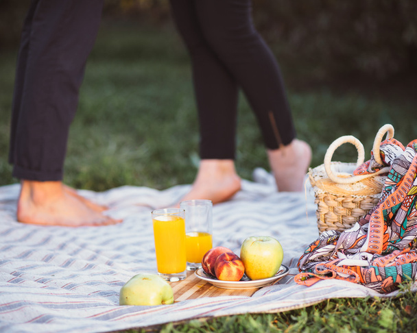 Pregnant couple on picnic. Fruit and a basket closeup - 写真・画像
