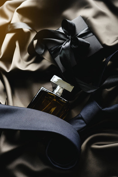 Elegant man accessories: tie, black gift box, perfume bottle on the satin textile. - Foto, Bild