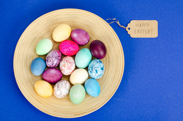 Decorated handmade Easter eggs for the holiday season on blue background. Creative minimal abstract concept. Photo - Foto, imagen
