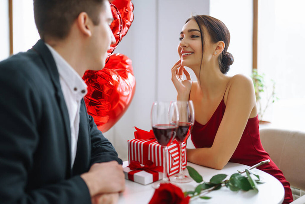 Valentine's Day concept. Romantic Date. Young couple celebrating Valentine's Day in the restaurant.  - Photo, Image