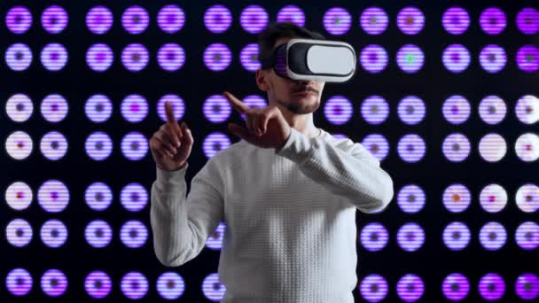 Man met een virtuele helm beweegt objecten en drukt op knoppen in de computerwereld. - Video