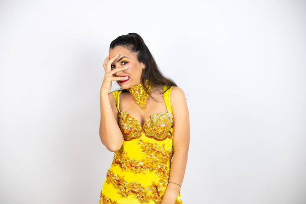Young beautiful woman wearing carnival costume over isolated white background peeking in shock covering face and eyes with hand, looking through fingers with embarrassed expression - Foto, imagen