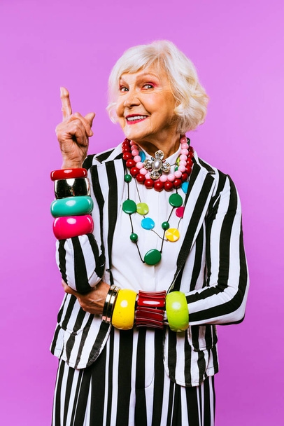 Happy and funny cool old lady with fashionable clothes portrait on colored background - Youthful grandmother with extravagant style, concepts about lifestyle, seniority and elderly people - Foto, imagen