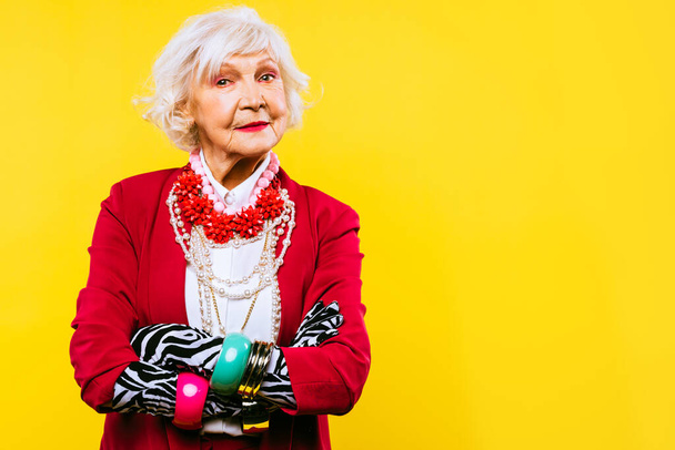 Happy and funny cool old lady with fashionable clothes portrait on colored background - Youthful grandmother with extravagant style, concepts about lifestyle, seniority and elderly people - Fotografie, Obrázek