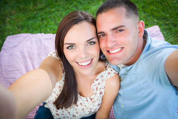 Felice giovane coppia caucasica tiro selfie nel parco. - Foto, immagini