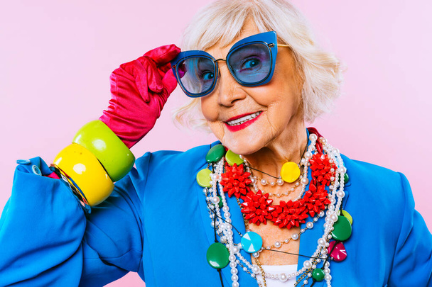 Boldog és vicces hűvös idős hölgy divatos ruhák portré színes háttér - Fiatal nagymama extravagáns stílus, fogalmak életmód, szenioritás és idősek - Fotó, kép