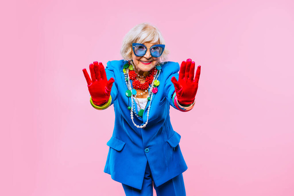 Happy and funny cool old lady with fashionable clothes portrait on colored background - Youthful grandmother with extravagant style, concepts about lifestyle, seniority and elderly people - Foto, Bild