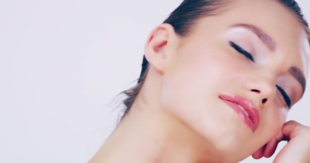 Glowing with gorgeousness. 4k video footage of a beautiful young woman touching her flawless skin in the studio. - Video