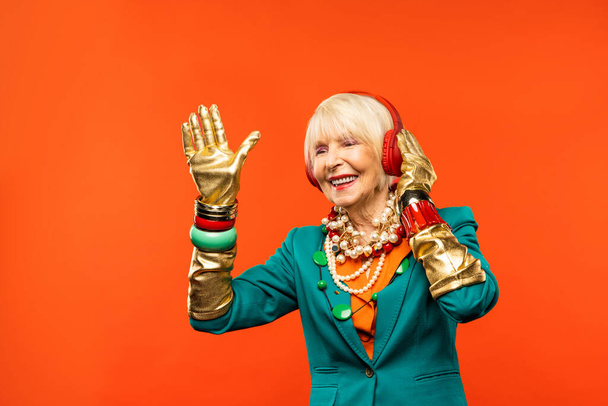 Happy and funny cool old lady with fashionable clothes portrait on colored background - Youthful grandmother with extravagant style, concepts about lifestyle, seniority and elderly people - Foto, Imagen