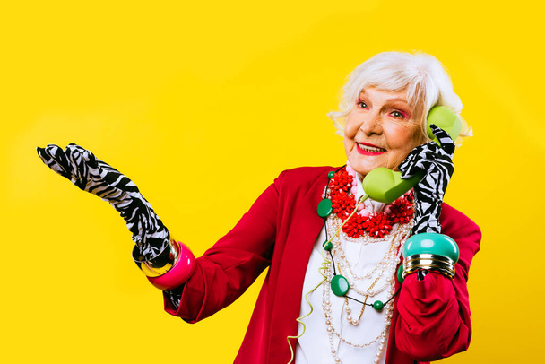 Happy and funny cool old lady with fashionable clothes portrait on colored background - Youthful grandmother with extravagant style, concepts about lifestyle, seniority and elderly people - Foto, Imagem
