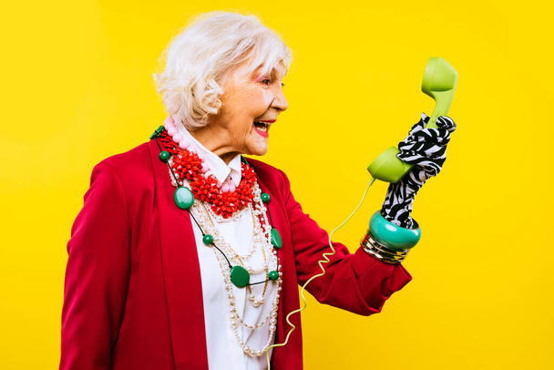 Happy and funny cool old lady with fashionable clothes portrait on colored background - Youthful grandmother with extravagant style, concepts about lifestyle, seniority and elderly people - Photo, Image