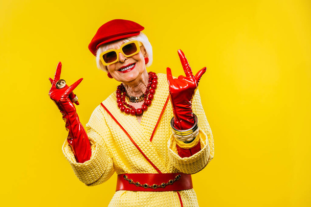 Happy and funny cool old lady with fashionable clothes portrait on colored background - Youthful grandmother with extravagant style, concepts about lifestyle, seniority and elderly people - Foto, afbeelding