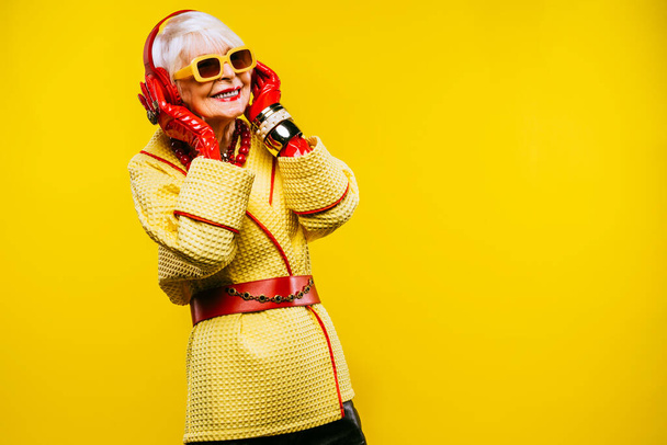 Happy and funny cool old lady with fashionable clothes portrait on colored background - Youthful grandmother with extravagant style, concepts about lifestyle, seniority and elderly people - Фото, зображення